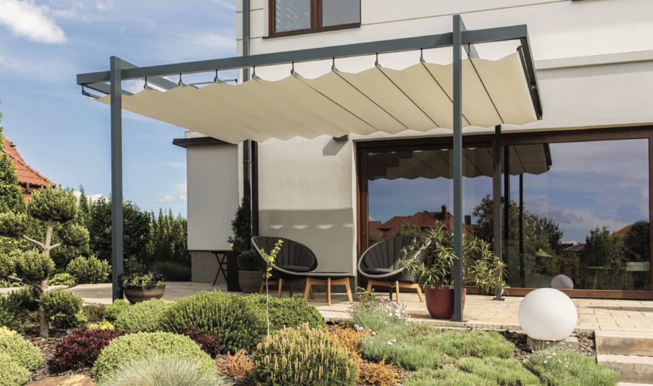 Elegante Terrassenüberdachung mit einem voll ausgefahrenen, hellen Stoffdach, das sich in dekorativen Wellen formt und stilvollen Sonnenschutz bietet.