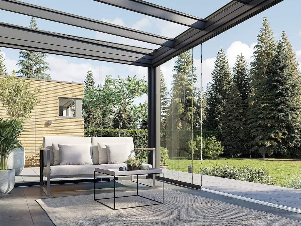 Das Schiebe-Dreh-System (z.B. SUNFLEX SF25) ist die eleganteste Lösung für den Kaltwintergarten. Die einzelnen Glasflügel sind nicht miteinander verbunden, sondern laufen separat in der Schiene. Der Clou: Sie schieben Paneel für Paneel zur Seite und drehen es dort um 90 Grad auf einen Parkplatz. So lässt sich die Front zu 100% öffnen – sogar über Ecken hinweg. Die Optik: Da dieses System ohne vertikale Rahmen auskommt (Ganzglas), genießen Sie auch im geschlossenen Zustand einen ungestörten Panoramablick ohne störende Pfosten. Perfekt für den Wetterschutz ohne optische Barrieren.